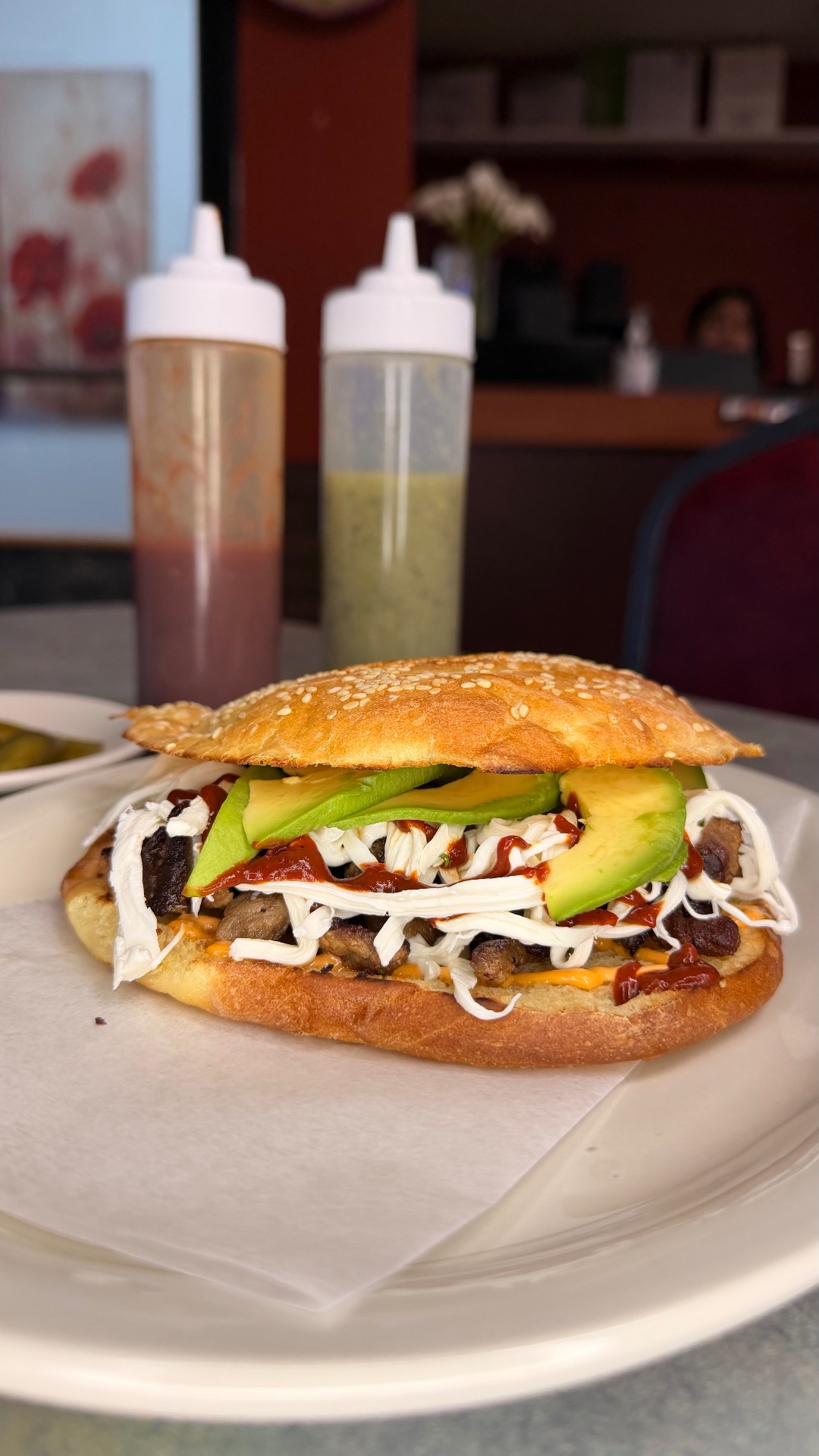 Semita sandwich with steak, avocado, queso fresco, and chipotle sauce on a sesame seed bun